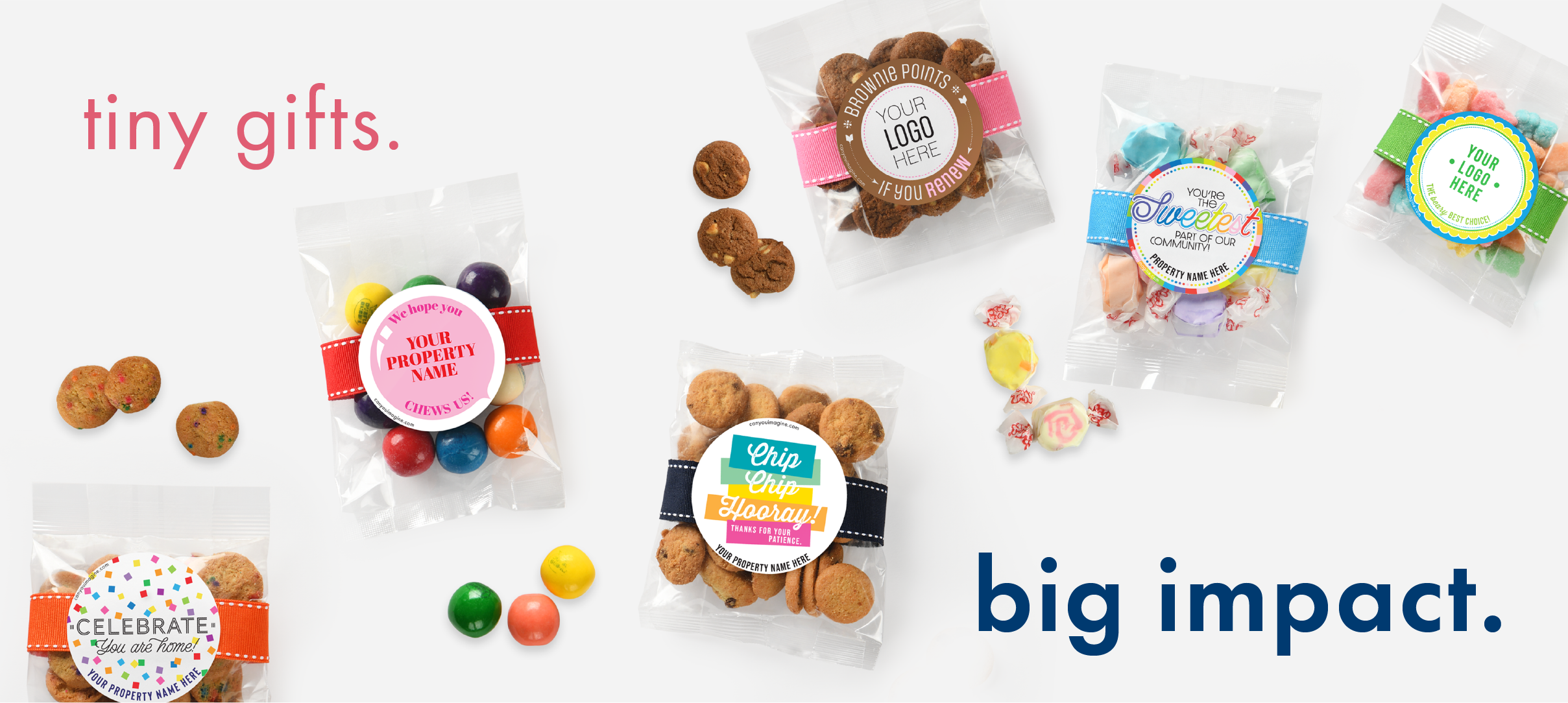 Small cello bags of cookies, taffy, gummy bears, and gumballs are sprawled out on a light gray background. Pink text reads "tiny gift." in the upper left corner. Blue, bolded test reads "big impact." in the lower right corner.